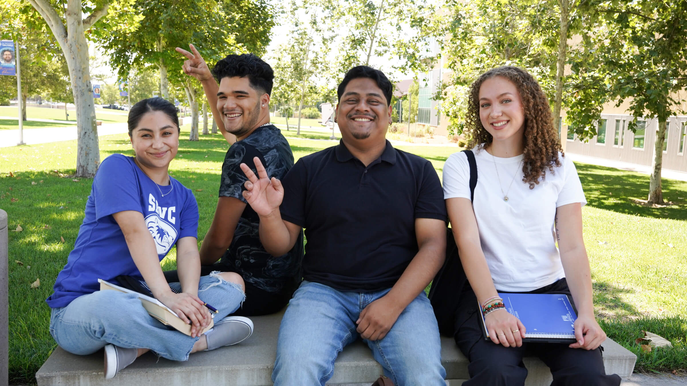 Students smiling on a bench