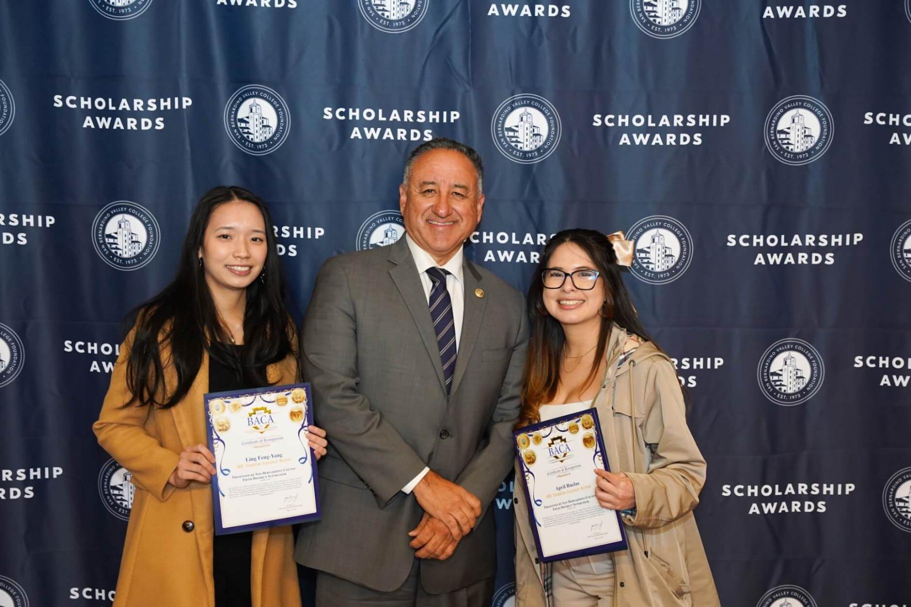 SBVC scholarship recipients Lina Feng-Yang (left) and April Ruelas (right), pose with San Bernardino County Supervisor Joe Baca, Jr.