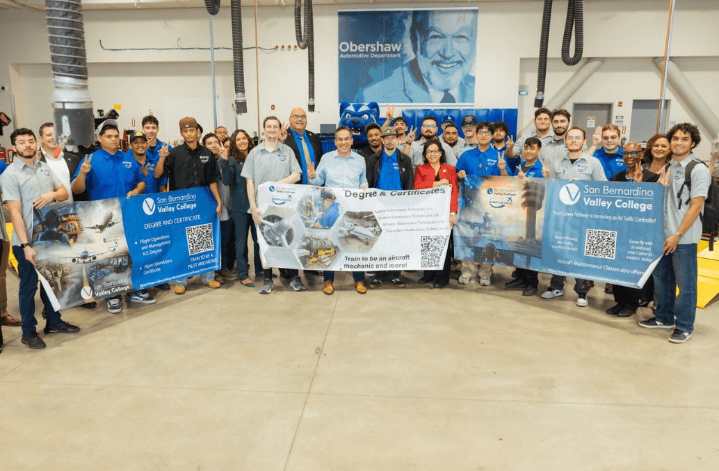 A group of students, faculty and staff standing together holding banners about sustainability
