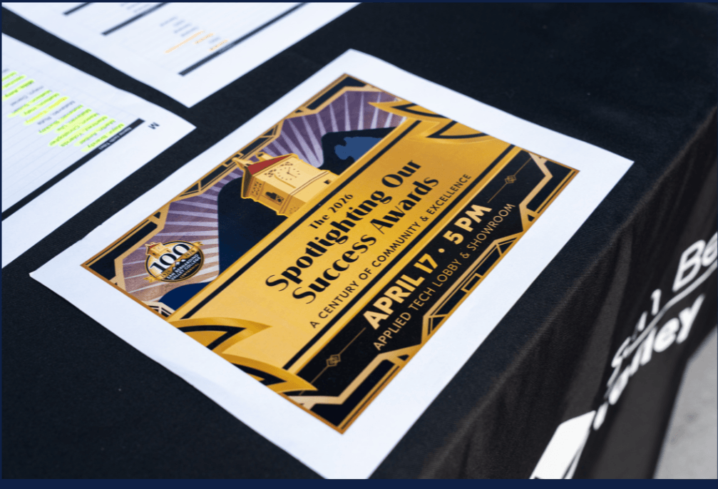Close-up photograph of a Spotlighting Our Success Awards program resting on a registration table during SBVC's 2026 employee recognition event.