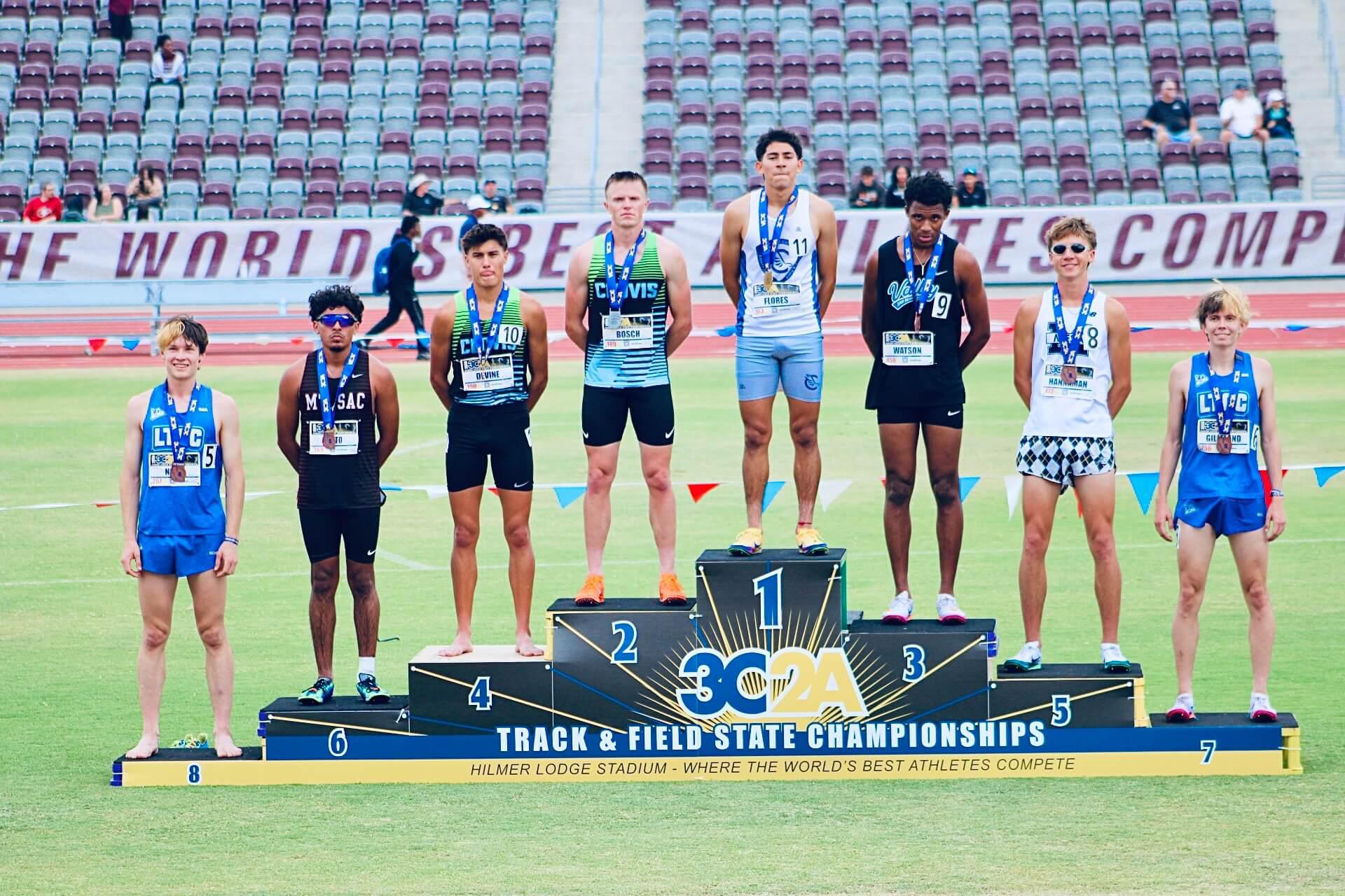 Medal-winning track and field athletes pose on and around the awards podium following an event at the 3C2A State Championships, with an SBVC athlete among the top finishers.