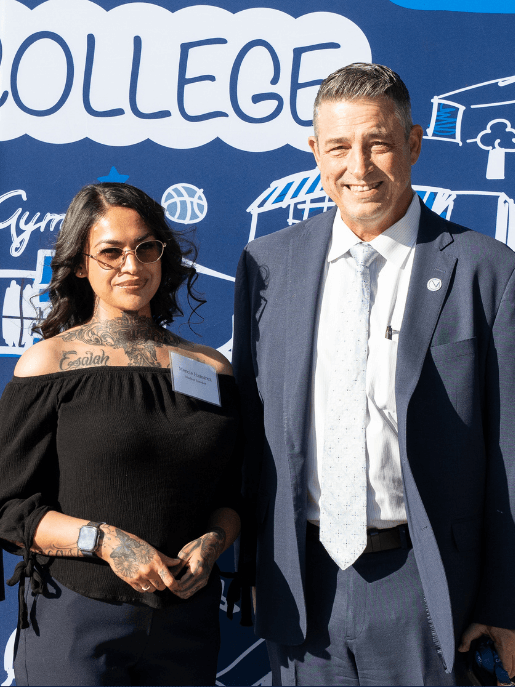 Student spotlight honoree Mercie Ramirez stands with an SBVC administrator in front of a college-branded backdrop during a campus recognition event.